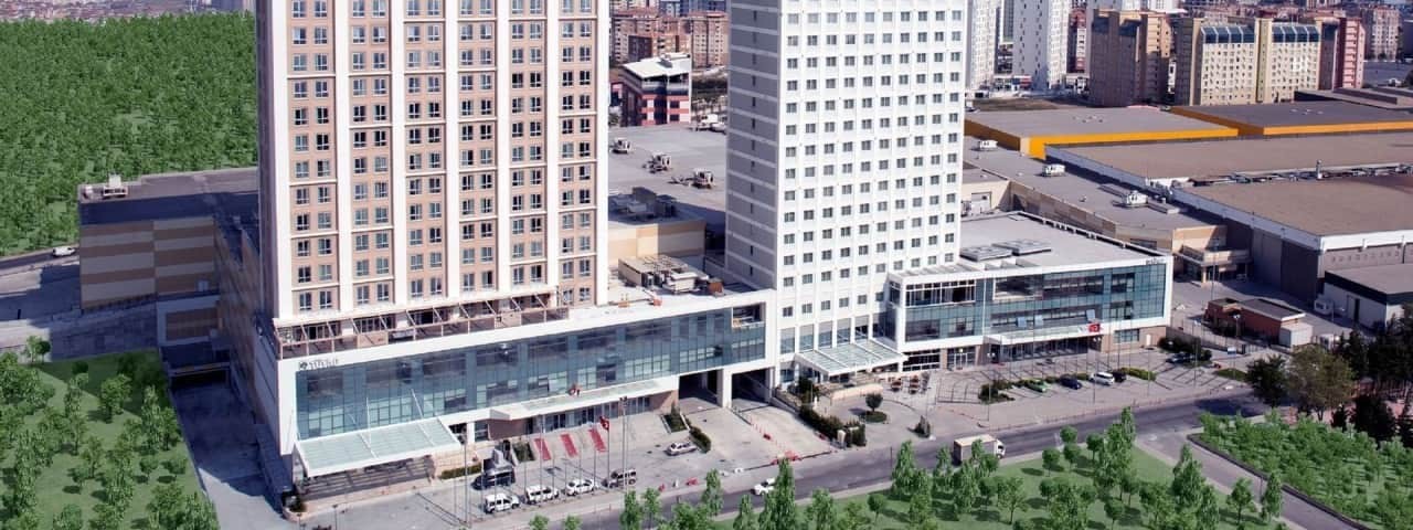 Exterior view of Tuyap Palas Hotel with a modern design surrounded by trees and other city structures