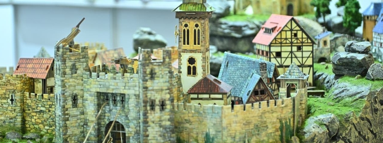 Detailed miniature medieval castle model with towers, stone walls, and timber framed houses at PROMOGIFT