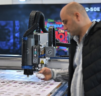 PROMOGIFT’te bir operatör CNC makinesi 'le promosyon malzemelerini kesiyor.
